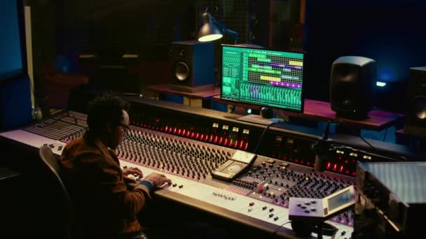 African American Sound Expert Operates Audio Console Moving Faders Colored — Stock Video
