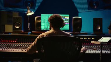 Pistleri düzenlemek ve işlemek için kontrol odasında çalışan ses teknisyeni, müzik endüstrisi sonrası prodüksiyon için bilgisayarda ses yazılımı kullanıyor. Yetenekli yapımcı karıştırma konsoluyla müzik yapıyor. Kamera B.