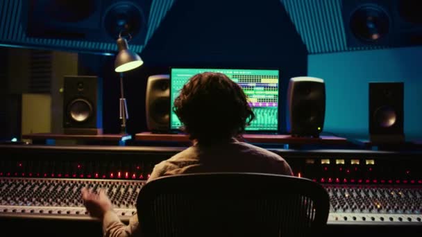 喜悦的音乐制作人在控制室欣赏他高质量的曲目 用旋钮和滑块完成项目 音频工程师在后期制作中混音 摄像头B — 图库视频影像