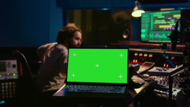 サウンドデザイナーは プロのスタジオでオーディオミキサーとグリーンスクリーンのレイアウトを使用し 机の上のボタンを押しながらボリュームレベルを調整します 技術的な録音装置が装備されているコントロールルーム カメラ — ストック動画