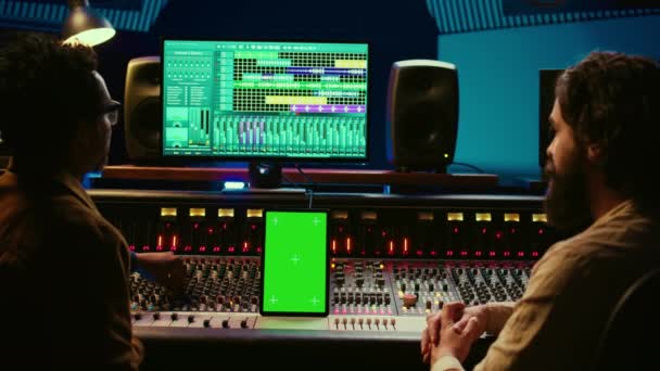 不同的音乐专家在平板电脑上使用绿色屏幕 在控制室里使用混合控制台 按下按键并按下滑块 艺术家和制作人在工作室创作了一首热门歌曲 摄像头B — 图库视频影像