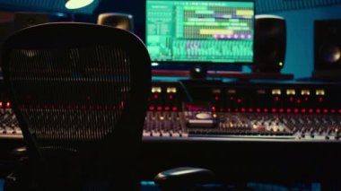 Profesyonel kayıt stüdyosundaki ses geçirmez oda, sürgülü ve faders paneli stereo ekipman. Ses kayıt yazılımıyla profesyonel prodüksiyon alanı.