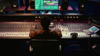 Afro-Amerikan ses mühendisi kayıt ve montaj parçalarını düğme ve şalterlerle karıştırarak post prodüksiyon yapıyor. Stüdyoda yeni müzik yapan yetenekli bir ses teknisyeni. Kamera B.