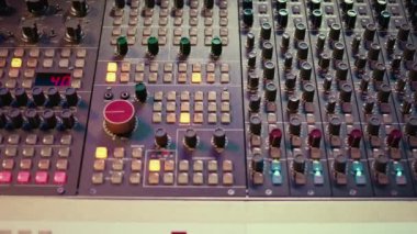 Konsol panelinin karıştırma işleminde ön amfi düğmeleri ve anahtarlar, müzik sonrası yapımında kullanılan ses stereo ekipmanları. Profesyonel stüdyoda boş bir kontrol odası var. Fader ve Sliders. Kapat..