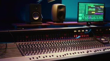 Kontrol masası mikseri ve ses kayıt yazılımı olan boş profesyonel stüdyo, müzik prodüksiyonu. Ses geçirmez kontrol odası anahtarlar, sürgüler ve ön amfi düğmeleri ile donatılmış..