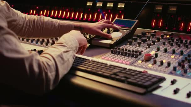 音效设计师在专业音乐录音室的控制台上与滑块和交换器一起工作 编辑和制作歌曲以制作新专辑 技术员调整音量水平 摄像头B — 图库视频影像