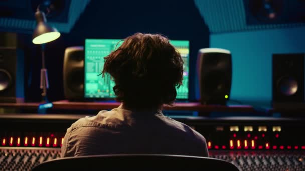 프로듀서는 녹음을 편집하고 콘솔의 버튼을 사용하여 사운드를 통합하여 오디오를 개발합니다 — 비디오