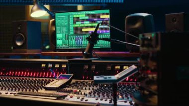 Ses parçalarını karıştırmak ve ustalaştırmak için kullanılan daw yazılımıyla müzik kayıt stüdyosu kontrol odası, ses geçirmez boş profesyonel alan. Ses dalgalarını düzenlemek için kontrol panelindeki modern kaydırıcılar.