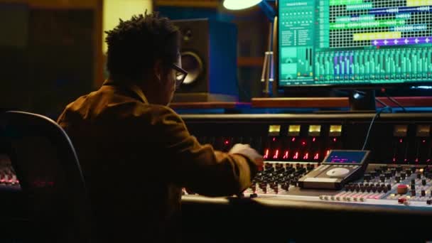 非裔美国人音响专家在音频控制台上操作 有活动的读取器和彩色计 在专业工作室控制室编辑 制作人制作专辑 录制热门歌曲 相机A — 图库视频影像