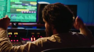 Neşeli, enerjik ses mühendisi profesyonel stüdyoda kendi müzik yaratımı üzerine dans ederek konsol ve daw yazılımının karışımını düzenliyor. Ses tasarımcısı işleme parçaları. Kamera A.