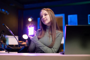 Stüdyoda küçük RGB ışıklarını incelemek için kamerayı kullanarak canlı yayın yapıyor. Çevrimiçi program sunucusu, elektronik çekimleri çekiyor, izleyicilere kablosuz LED aydınlatma aygıtı sunuyor