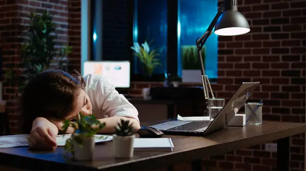 睡眠中の従業員は レンガの壁のオフィスで夜遅くコンピュータデスクで眠っている ラップトップ カメラAで一晩働いている間 テーブルの上に頭で寝ている疲れたビジネスマンのパンニングショット — ストック写真