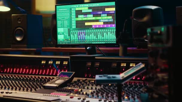 ミュージックレコーディング業界で使用される空のコントロールルームのプロのスタジオ コンソールとポスト生産設備 ソフトウェア オーディオ編集ツールを備えた防音スペース — ストック動画
