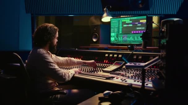 プロのレコーディングスタジオでサウンドエンジニアのミキシングとマスタリングトラック ボリュームレベルを調整し オーディオ録音を編集するためのソフトウェアとプッシュスライダー コントロールルーム カメラ — ストック動画
