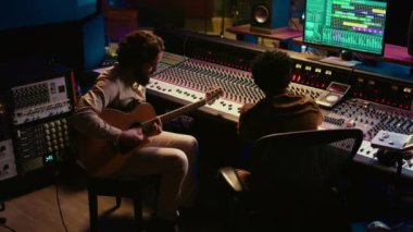 Yetenekli sanatçı profesyonel stüdyosunda gitarıyla canlı performans sergiliyor, ses uzmanıyla yeni şarkılar kaydediyor. Ses mühendisi onun için şarkıları karıştırıp ustalaştırıyor. Kamera B.