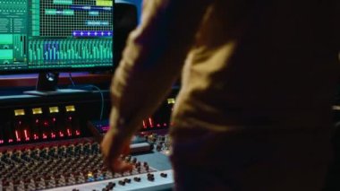 Müzik yapımcısı stüdyoda konsol ve ses yazılımlarını karıştırarak şarkıları düzenliyor, tuşlara basıyor ve kontrol odasındaki düğmeleri çeviriyor. Ses mühendisi melodi üretiyor ve sesi ayarlıyor. Kamera A.