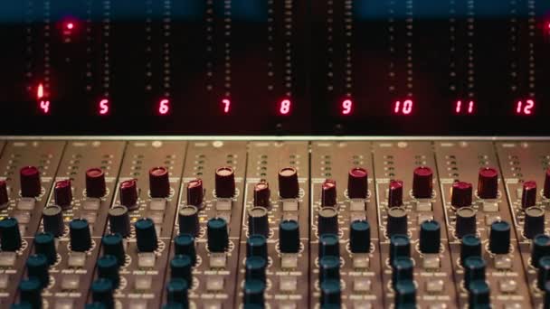 コントロールデスクミキサーとプリアンプノブ 音楽録音 オーディオソフトウェアで編集する空のプロのスタジオ ポスト生産 防音スペースのコントロールルームボタンとスライダー — ストック動画