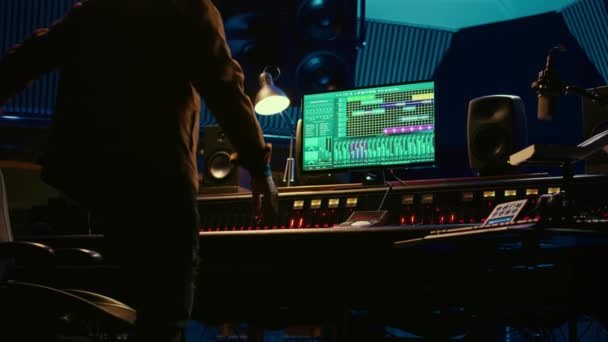 非裔美国人声乐设计师经营控制台混音器和音频软件 用于编辑曲目 制作人与交换器 机动读取机一起工作 播放流行歌曲 摄像头B — 图库视频影像