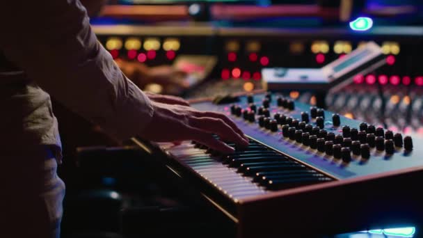 熟练的艺术家在控制室中弹奏钢琴电子键盘 用Midi控制器和混合控制台录制新的曲目 年轻音乐家在录音室里的合成器上练习 相机A — 图库视频影像