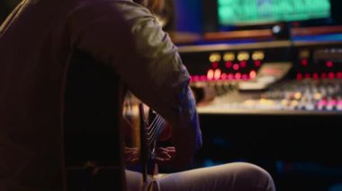 Profesyonel stüdyoda canlı performans sergileyen yetenekli bir gitarist konsol amplifikatörüne yeni şarkılar kaydediyor. Genç müzisyen yeni şarkılar söylüyor, müzik yapıyor. Kamera A.