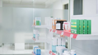 İlaçlar ve raflardaki takviyelerin seçici odak noktası, reçeteli ilaç ve tıbbi malzemelerle dolu boş eczane. Eczanede satılık antibiyotikler ve eczane var..