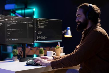 Yazılım uygulamaları tasarlarken ve geliştirirken serbest programcı işitme cihazları. IT uzmanı şirket sistemlerini uygularken ve sürdürürken podcastlardan keyif alıyor