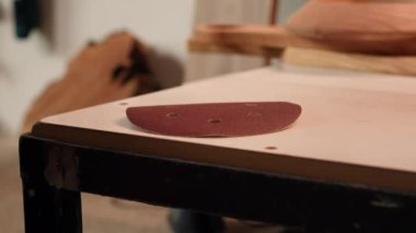 Marangoz plastik parçasına zımpara kağıdı koyup pürüzsüz yüzeylere aşındırıcı sünger yapıyor. Mobilya montajı işi için gerekli malzemeleri hazırlayan adam, yakın çekim, kamera A