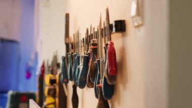 Tahta yüzeyleri oymak için kullanılan mobilya montaj dükkanının duvarında maşa, tornavida, İngiliz anahtarı ve kerpeten var. Marangozluk stüdyosundaki marangozluk malzemelerini kapatın.
