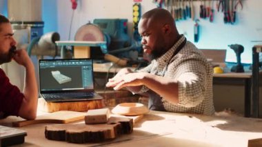 Carpenter, CAD yazılımında çırağıyla birlikte dizüstü bilgisayardaki planları inceliyor. Tahta işçileri stüdyoda defter üzerine özel 3D mobilyalar tasarlıyorlar. Müşteri siparişine hazırlanıyorlar. Kamera A.