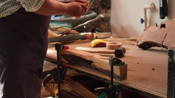 アフリカ系アメリカ人メーカーは チゼルとハンマーを使用した生木材を形作り 木材アートを生み出し 正確な削減を行っています 手作りの木彫りを作るアーティスト 道具が付いている木材を彫刻する カメラAの近く — ストック動画