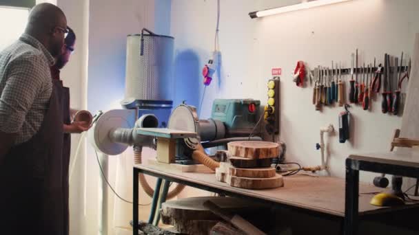 生产厂家教新员工如何在组装车间用圆盘砂子做木碗 学徒向木工专家学习如何使用磨床旋转盘 照相机B — 图库视频影像