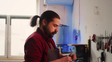 Marangoz, kaliteli ahşap malzemeler seçerken güvenlik gözlüğü takıyor ve proje şartlarını yerine getiriyor. Kabin yapımcısı koruyucu giysi giyiyor, kereste bloğunda kalite güvencesi veriyor, kamera B