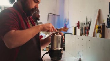 Mobilya montajında çalışan tamirci, çim biçme makinesinin pervanesini değiştiriyor. Ahşap işçiliği stüdyosundaki mühendis arızalı ahşap şekillendiriciyi tamir ediyor, hasarlı parçayı değiştiriyor, kamera B