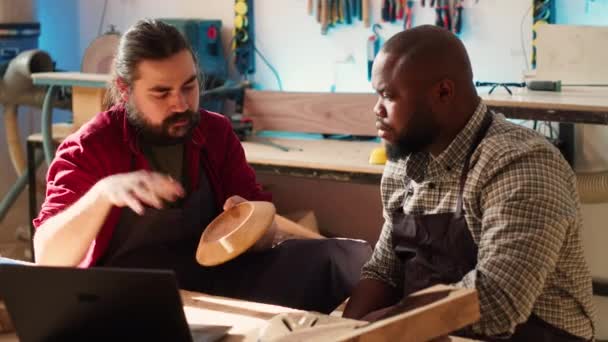 Träarbetare Tittar Över Ritningar Laptop Brainstormar Med Afrikansk Amerikansk Lärling — Stockvideo