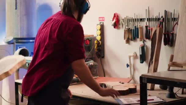 Ξυλουργός Στην Εργασία Συμβουλεύει Σχέδιο Χρησιμοποιώντας Τροχιακό Τριβείο Ξυλεία Φορώντας — Αρχείο Βίντεο
