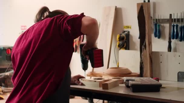 Dowels를 구멍을 창조하는 교련을 사용하는 상점에 Woodworker 공구를 나무로 표면으로 — 비디오