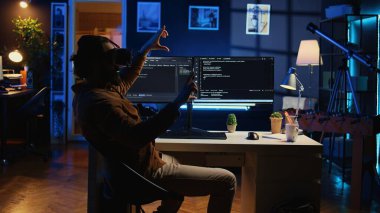 Dahili ofiste kodlama yapmak için teknolojik olarak gelişmiş VR gözlükleri kullanan serbest çalışan bir mühendis. Kod satırlarını görselleştirmek için ileri teknoloji sanal gerçeklik kulaklığı takan serbest çalışan bilişim uzmanı