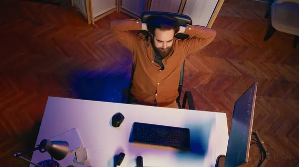从上往下看总部办公室的It管理员在坐了一整天后伸懒腰 软件工程师松懈 长时间在电脑上打字后放松 空中射击 — 图库照片