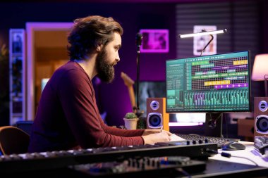 Müzikal besteci, yeni şarkı sözleriyle birlikte ses ekipmanlarıyla müzik kaydediyor. Şarkıcı şarkı sözü yazarı notalar alır, notalar ve melodik öğeler besteler, müzik üretir..