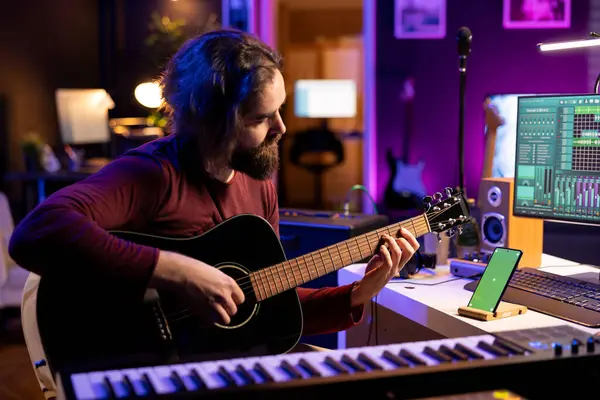 Musiker Spielen Ein Akustisches Instrument Neben Dem Greenscreen Auf Dem lizenzfreie Stockbilder