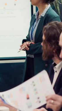 İş arkadaşlarından oluşan bir ekip, yaklaşan etkinliklerin gündemini tartışıyor, girişimin başarısını sürdürmek için kaynakların planlanması ve koordinasyonunu yapıyor. Çalışanlar güncellemeleri iletir ve öncelikleri sıralarlar. Kamera A.