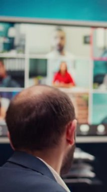 İş ortakları, yeni bir kalkınma projesi hakkında bilgi ve güncellemeleri paylaşmak üzere bir video çağrısı bağlantısı hakkında hissedarlarla görüşüyor. Yönetim kurulu üyeleri sıkı büyümeyi tartışıyor. Kamera B.