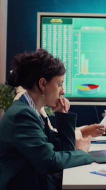 İşletme müdürü, borsa eğilimlerinin ilerlediğini görmek için muhasebeciyle yaptığı telefon görüşmesinde, gelişmekte olan bir proje için daha fazla fon almak üzere yardımcısını aradı. Toplantı odası. Kamera B.