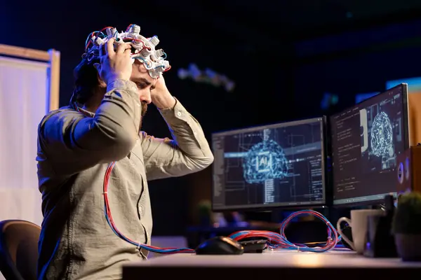 stock image Computer scientist puts EEG headset on, starting mind upload process, trying to gain bionic powers. Man using high tech neuroscientific gear to transfer consciousness into cyberspace