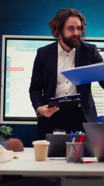 Girişim ekibi yürütme toplantısında stratejik planlar ve finansal tahminler üzerinde tartışıyor, yönetici bilgi grafikli panolar veriyor. Veri raporları ile kaynak tahsisine karar veriliyor. Kamera B.