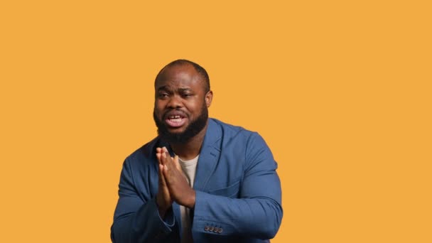 アフリカ系アメリカ人男性がジェスチャーを乞い 願いを叶え イエロースタジオの背景に隔離された 何かを求めているBipocの人 祈りと希望 カメラA — ストック動画