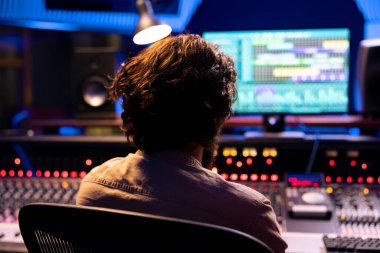 Ses tasarımcısı ses kayıtlarını faders ve düğmeleri ile birlikte profesyonel müzik stüdyosundaki kontrol masasında ayarlıyor, yeni bir albüm için şarkıları karıştırıyor ve ustalaştırıyor. Ses düzeyi eşitleyici ile ayarlanıyor.