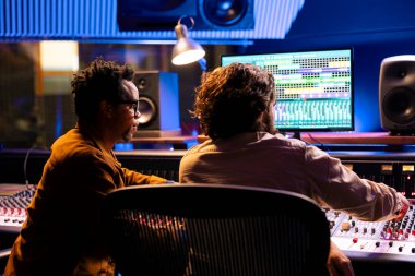 Profesyonel stüdyoda müzik kaydetme ve düzenleme üzerine çalışan teknik mühendislerden oluşan bir ekip, yeni bir hit şarkı yaratmak için karışık ve ana ses dosyaları üzerinde çalışıyorlar. Sanatçı ve kontrol odası uzmanı.