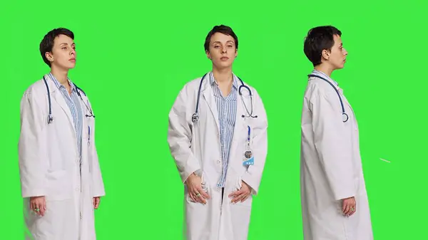 スタジオで白い病院のコートを着た健康専門家の肖像画は 緑色の背景に立っています 自信を持ってポーズをとる成功した医師 医療業界の専門知識 カメラ ストックフォト