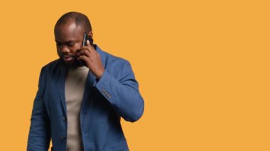 Olumlu duyguları olan neşeli bir adam, telefon görüşmesinde arkadaşlarıyla konuşmaktan zevk alan akıllı telefon kullanan, stüdyo geçmişi olan. Yüzünde gülümseme olan mutlu bir insan, telefon görüşmesi sırasında iyi haberler alıyor, kamera A